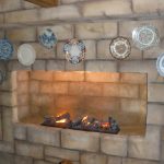 Φωτογραφία: Ψεύτικο πέτρινο Τζάκι με ψεύτικη φωτιά στολισμένο με ζωγραφισμένα πιάτα