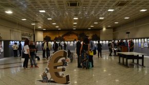 Φωτογραφία της αίθουσας με επισκέπτες στο χώρο. Υπάρχει τρισδιάστατο σκίτσο με ανθρώπους δεμένους (σκλάβους) σε ένα ευρώ.