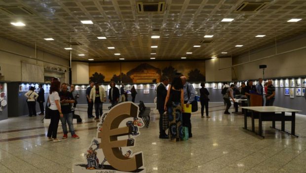 Φωτογραφία της αίθουσας με επισκέπτες στο χώρο. Υπάρχει τρισδιάστατο σκίτσο με ανθρώπους δεμένους (σκλάβους) σε ένα ευρώ.